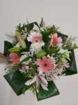 Bouquet con gerberas y lilium en hojas